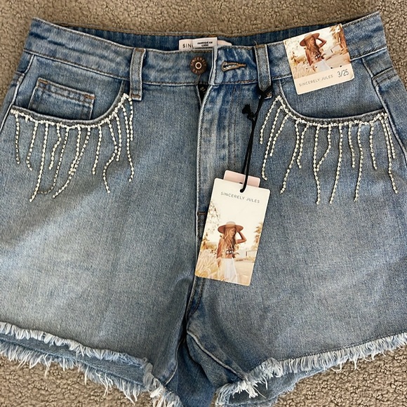 Denim cut off shorts with rhinestone fringe on pockets. Size 3/25 - Picture 3 of 4